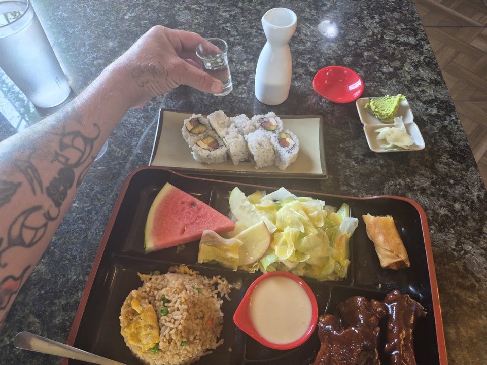Bento boxes beside bowls of ramen.