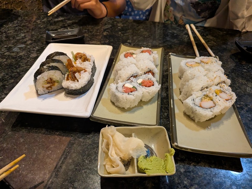 Sushi rolls arranged on a simple plate.