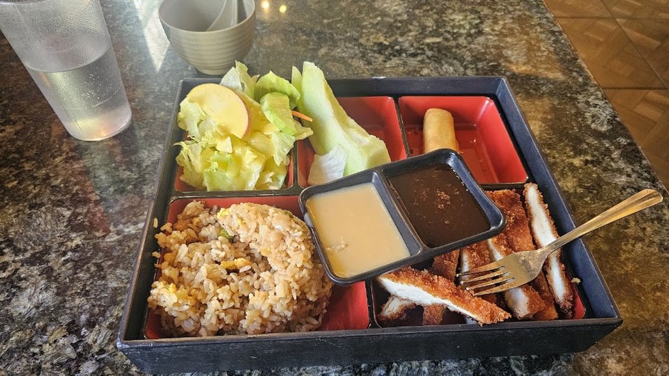 Printed menu with ramen, rolls, and bento boxes.